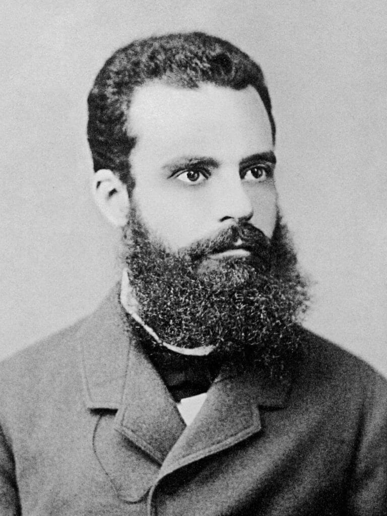 O sociólogo e economista Vilfredo Pareto, origem da Regra de Pareto e da Curva ABC. Na imagem, uma fotografia em preto e branco de um homem de barba longa e espessa, branco, cabelos curtos, usam roupas sociais de sua época.